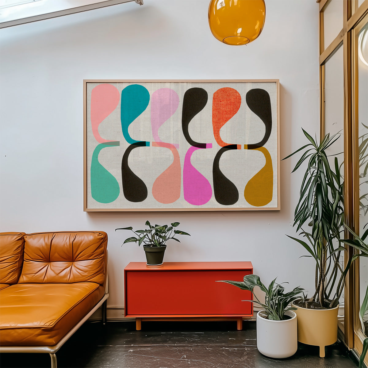 Modern living room with a brown leather sofa, colorful abstract art, and potted plants.