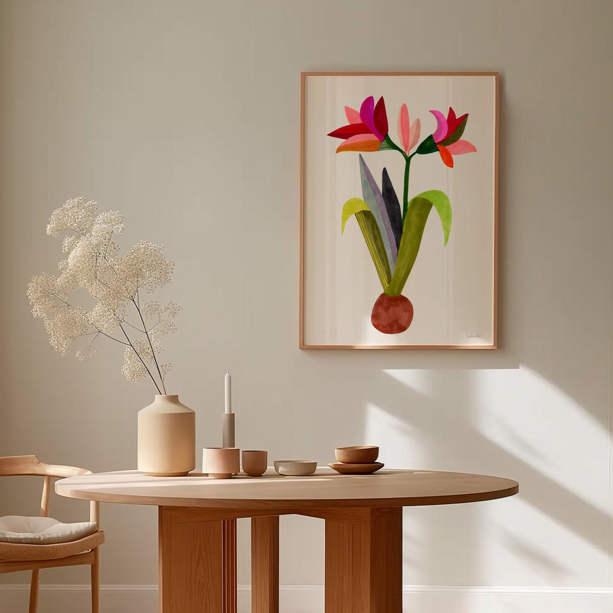 An archival art print titled 'Amaryllis Full Bloom' featuring a colorful illustration of Amaryllis flowers, displayed on a wall above a wooden table with a vase and other decor.